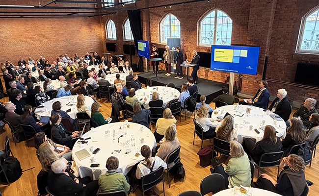 Människor vid bord i konferenslokal
